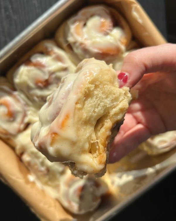 a person is holding up some food in a box and it looks like they are going to eat something