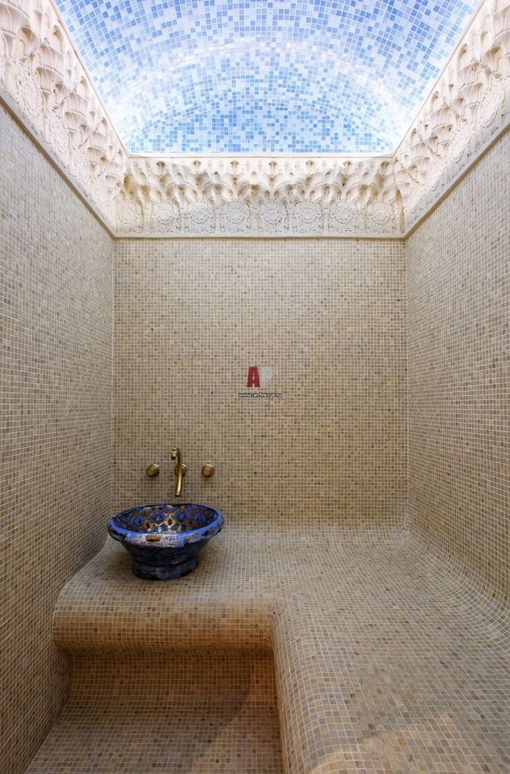 a blue bowl sitting on top of a step in a bathroom under a skylight