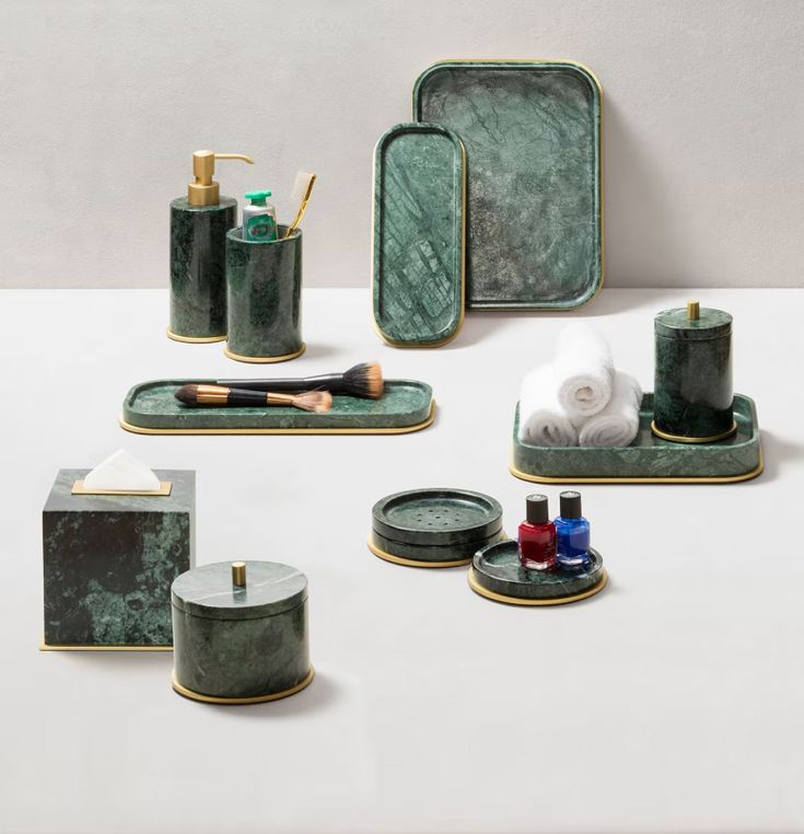 green marble bathroom accessories set on white surface