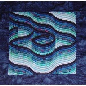 a quilted wall hanging with blue and green waves