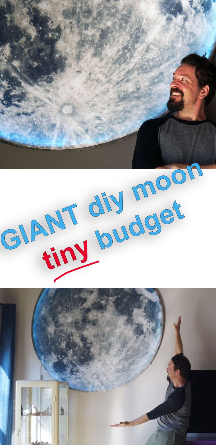 a man is standing in front of a giant moon and pointing at it with his hand