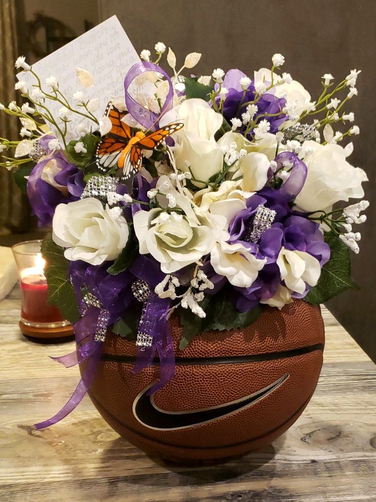 a basket filled with white and purple flowers sitting on top of a table