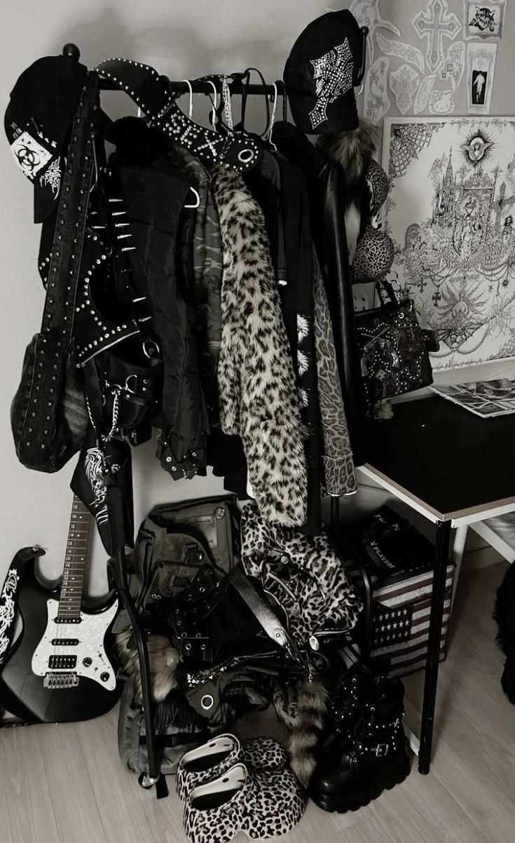 a black and white photo of clothes, guitars, and other items in a room