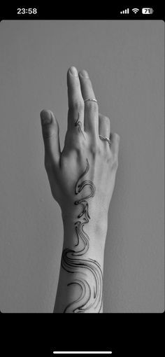 a person's hand with a tattoo on their arm and wrist is shown in black and white