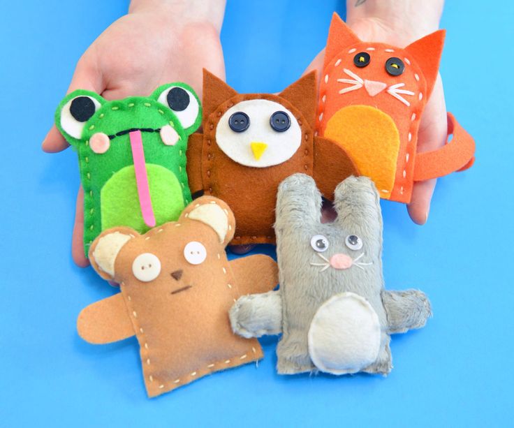 several stuffed animals are placed together in the shape of people's hands on a blue background