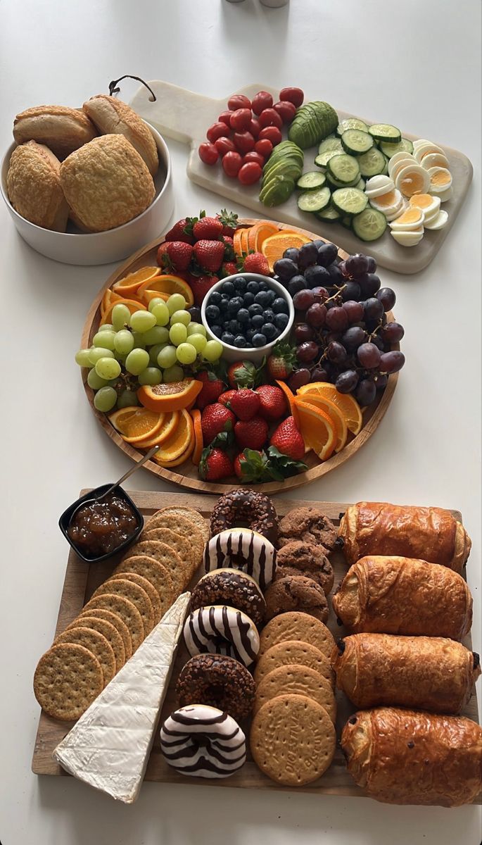 an assortment of fruits and pastries are arranged on a platter, along with other snacks