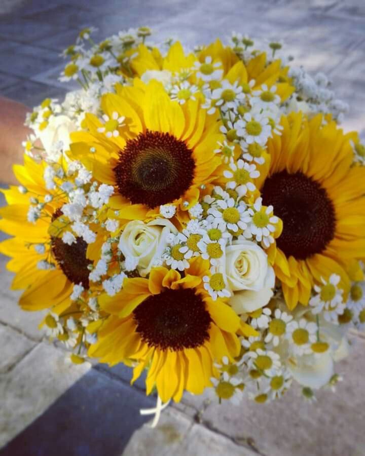 a bridal bouquet with sunflowers and baby's breath in the center