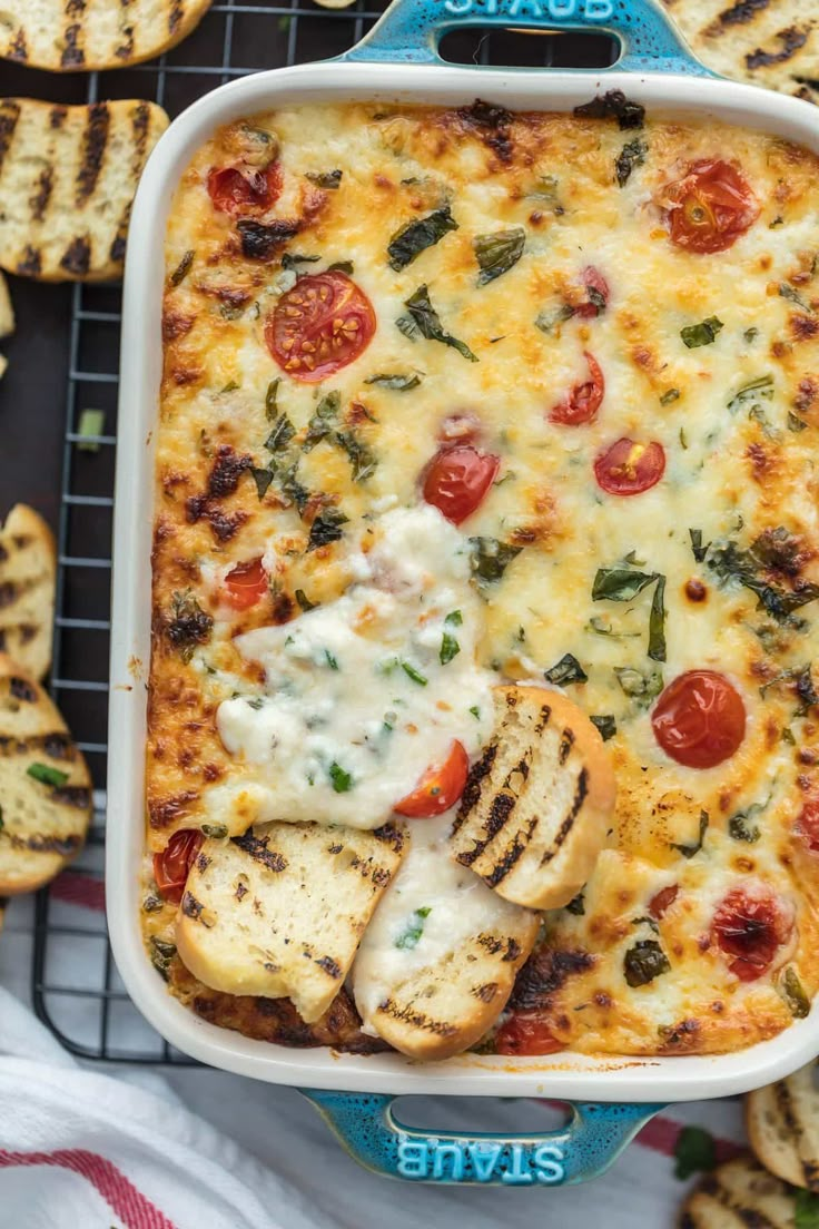 a casserole dish with chicken, tomatoes and cheese