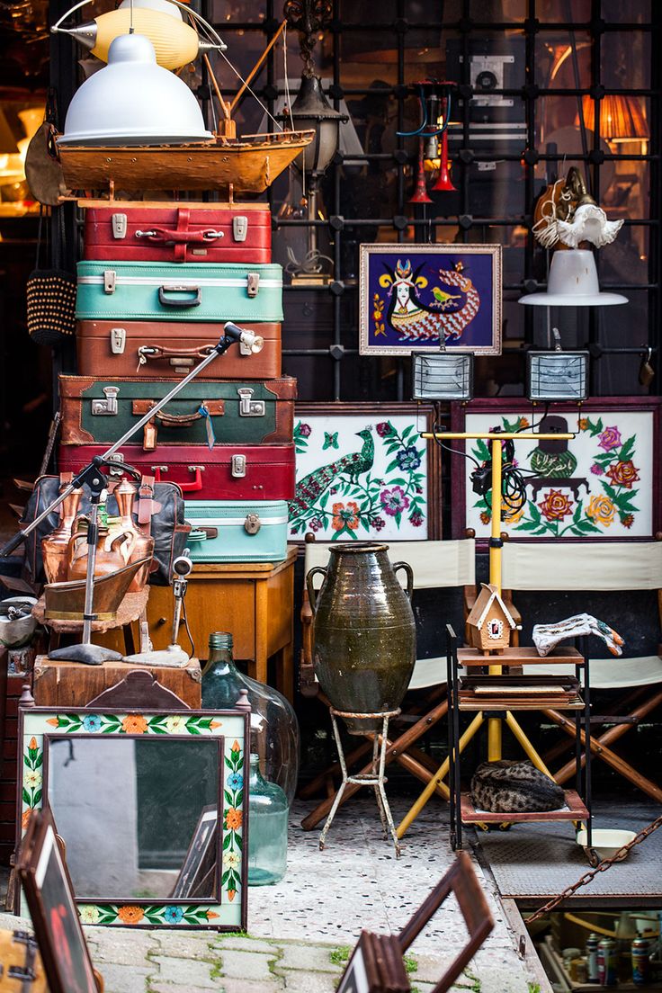 many pieces of luggage are stacked on top of each other in front of a store window