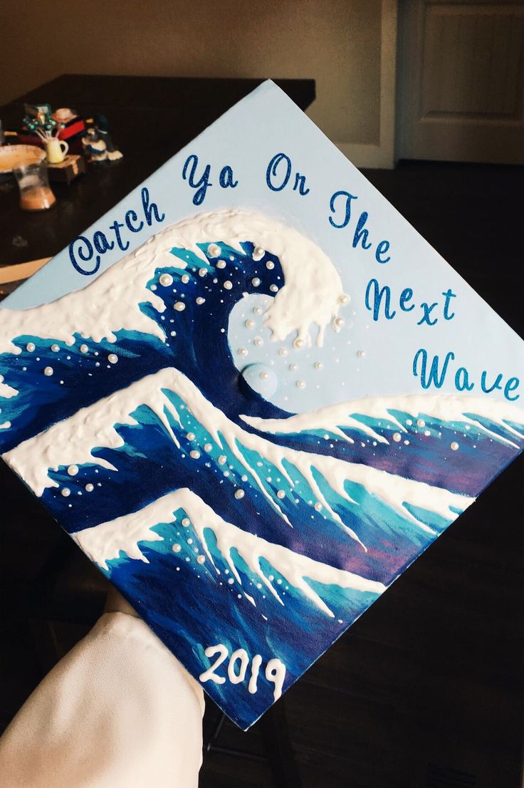 a decorated graduation cap that says coach on the next wave in blue and white waves