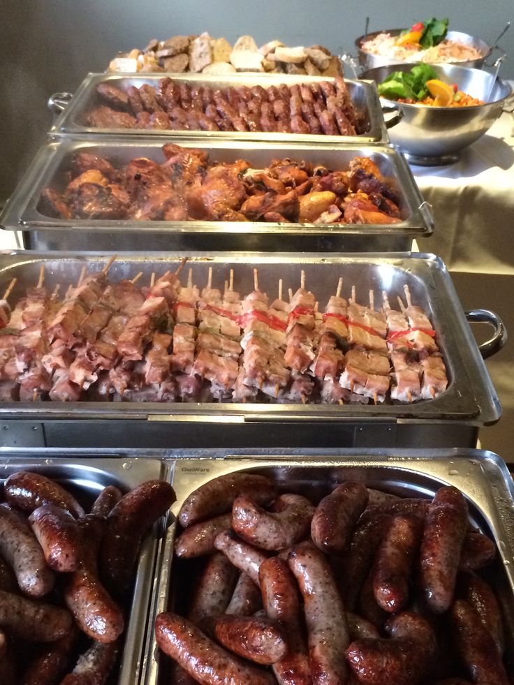 several trays filled with different types of meat on skewered skewers