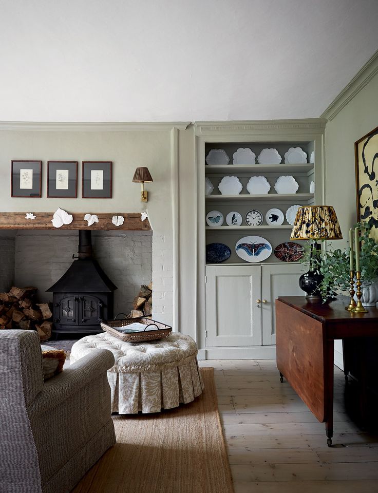 a living room filled with furniture and a fire place next to a wall mounted oven