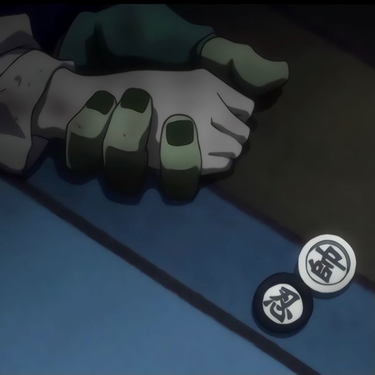 two buttons sitting next to each other on the floor in front of a person's hand