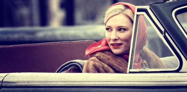 a woman sitting in the driver's seat of a car with a scarf on her head