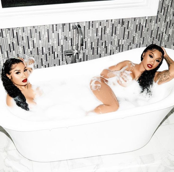 two women are sitting in the bathtub together