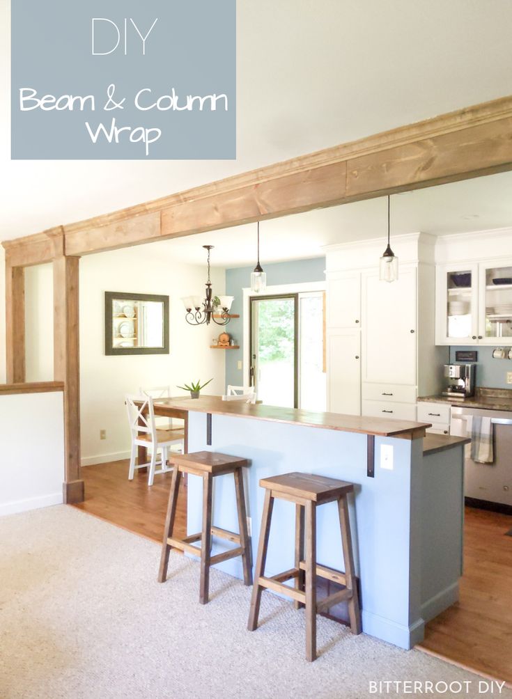 a kitchen with two bar stools next to an open floor plan and white cabinets