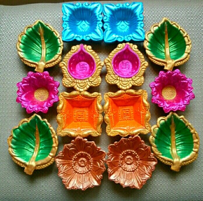 six different colored flower shaped trays sitting on top of a gray cloth covered table