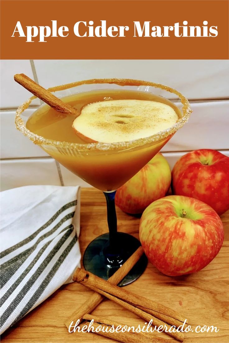 an apple cider with cinnamon stick garnishes and apples on the side