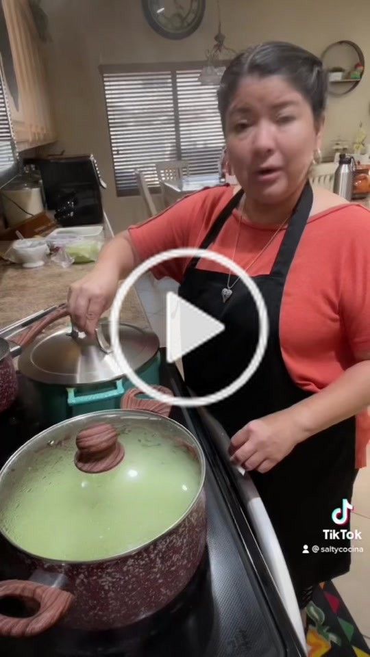 the woman is cooking in the kitchen with her hands on the stove and making food