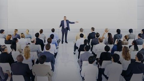 a man standing in front of a group of people at a business meeting or presentation