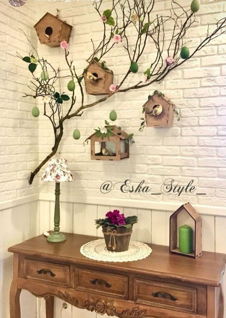 a wooden table with flowers and birdhouses on the wall above it, along with other decorations