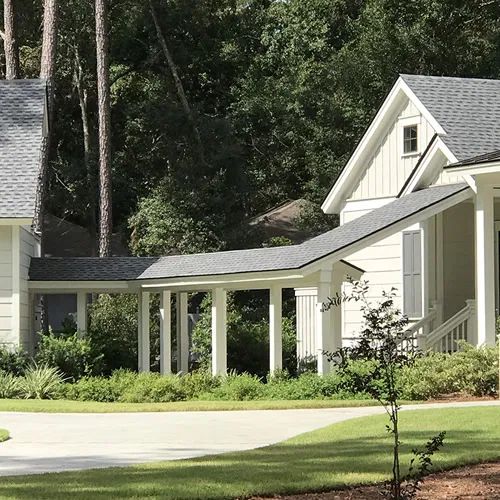 a white house surrounded by trees and grass