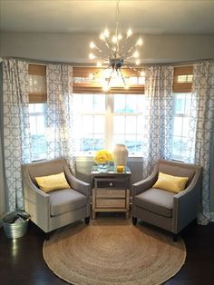 a living room with two chairs and a rug on the floor in front of a window