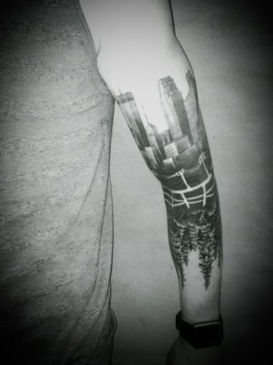 a man's arm with a black and white tattoo design on the left arm