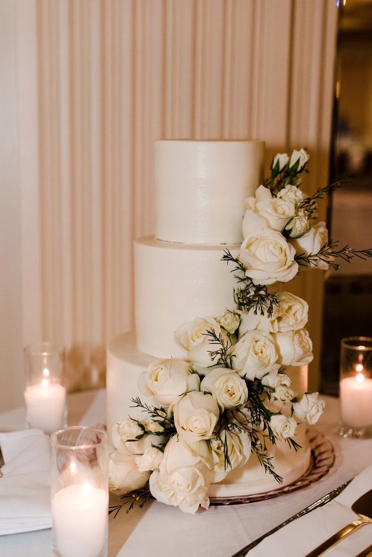 a wedding cake with white flowers and candles