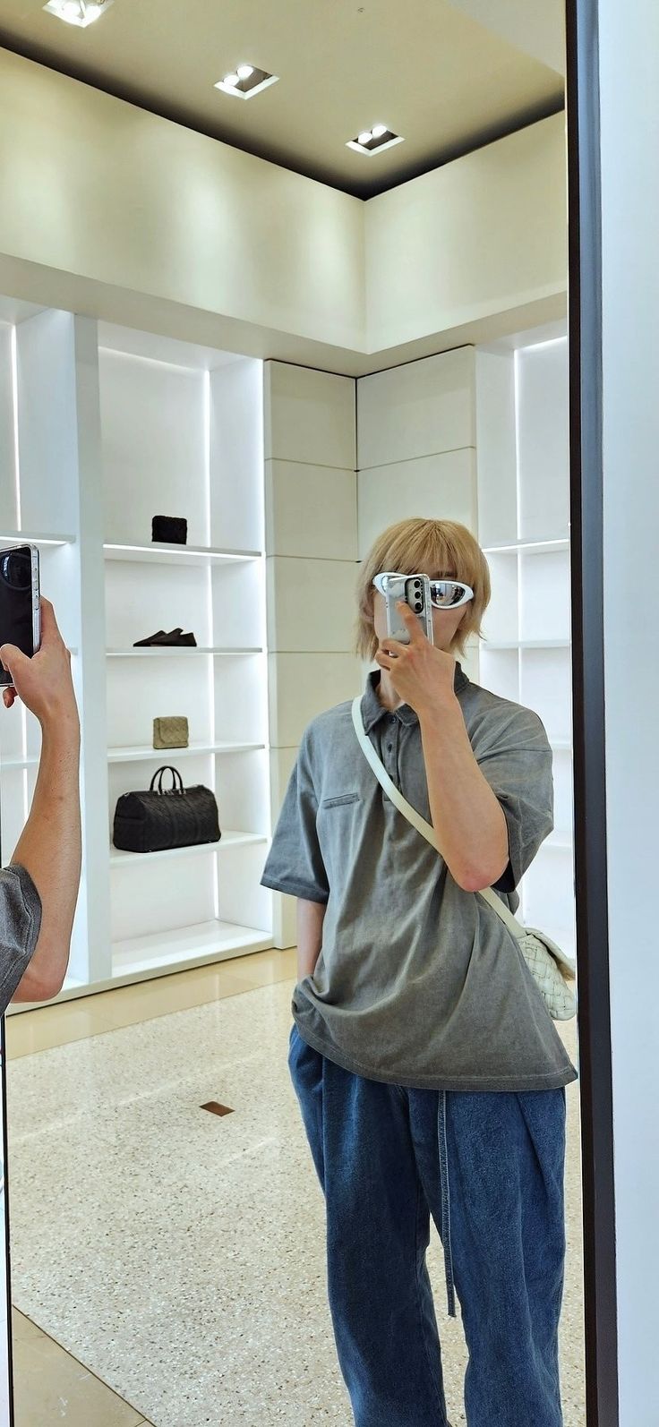 a man is taking a photo of himself in the mirror with his cell phone and wearing sunglasses