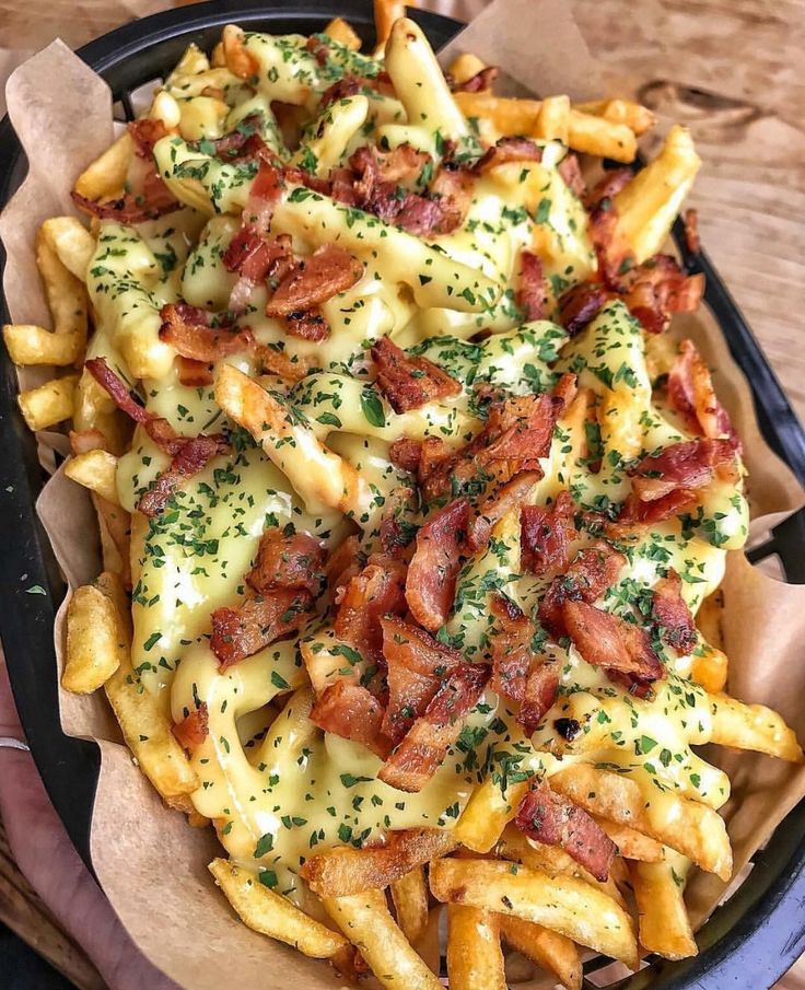 a basket filled with cheesy fries covered in bacon