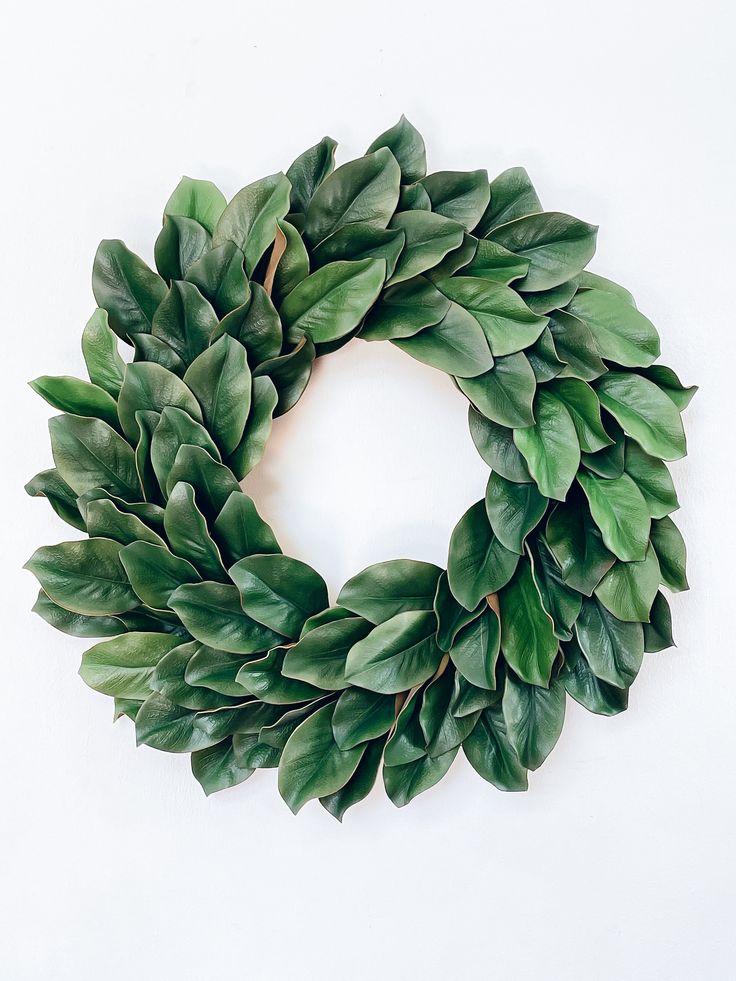 a wreath made out of green leaves on a white background