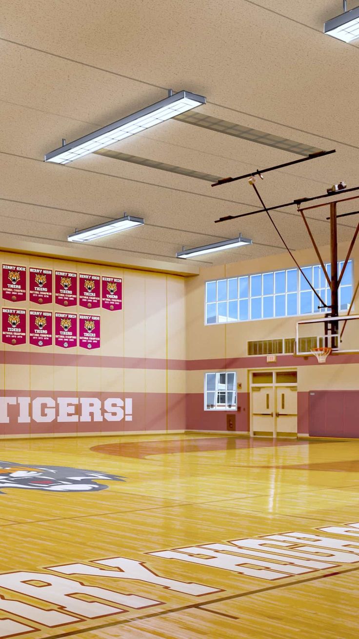 the inside of a school gym with basketball hoops and banners on the wall that read go tigers