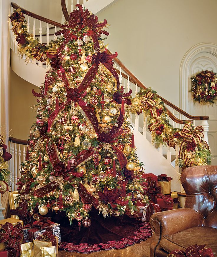 a decorated christmas tree in the corner of a living room with stairs and banisters