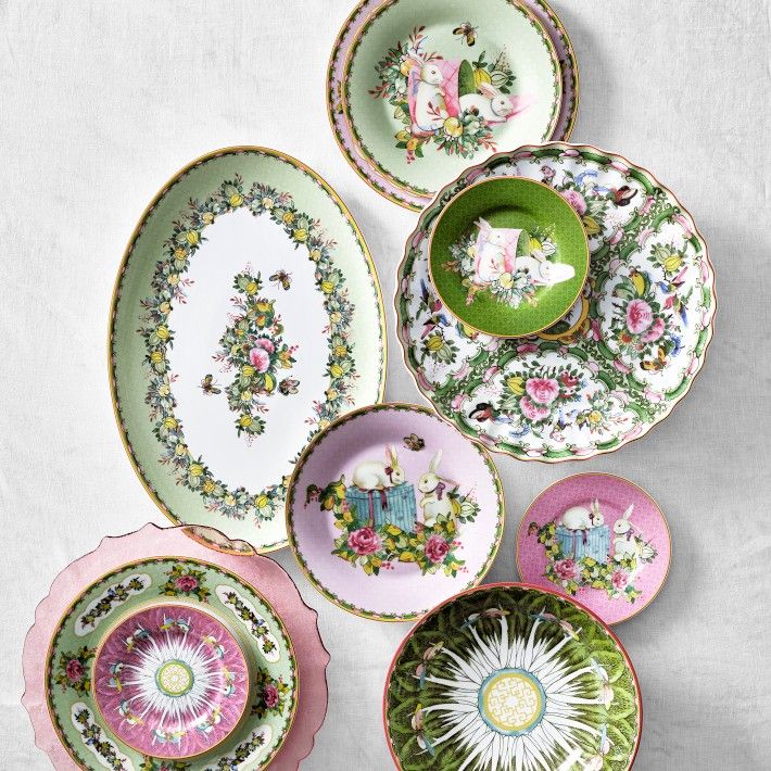 a collection of porcelain plates and saucers with animals on them, all decorated in different colors