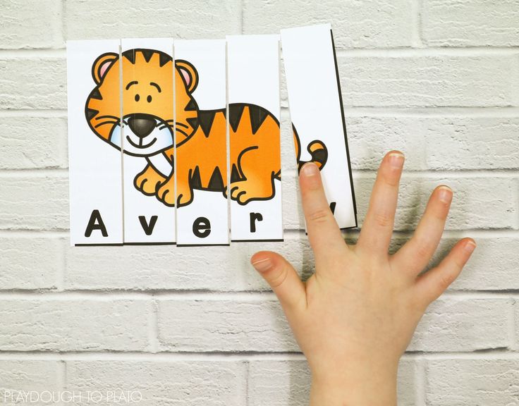 a child's hand holding up a piece of paper with a tiger on it