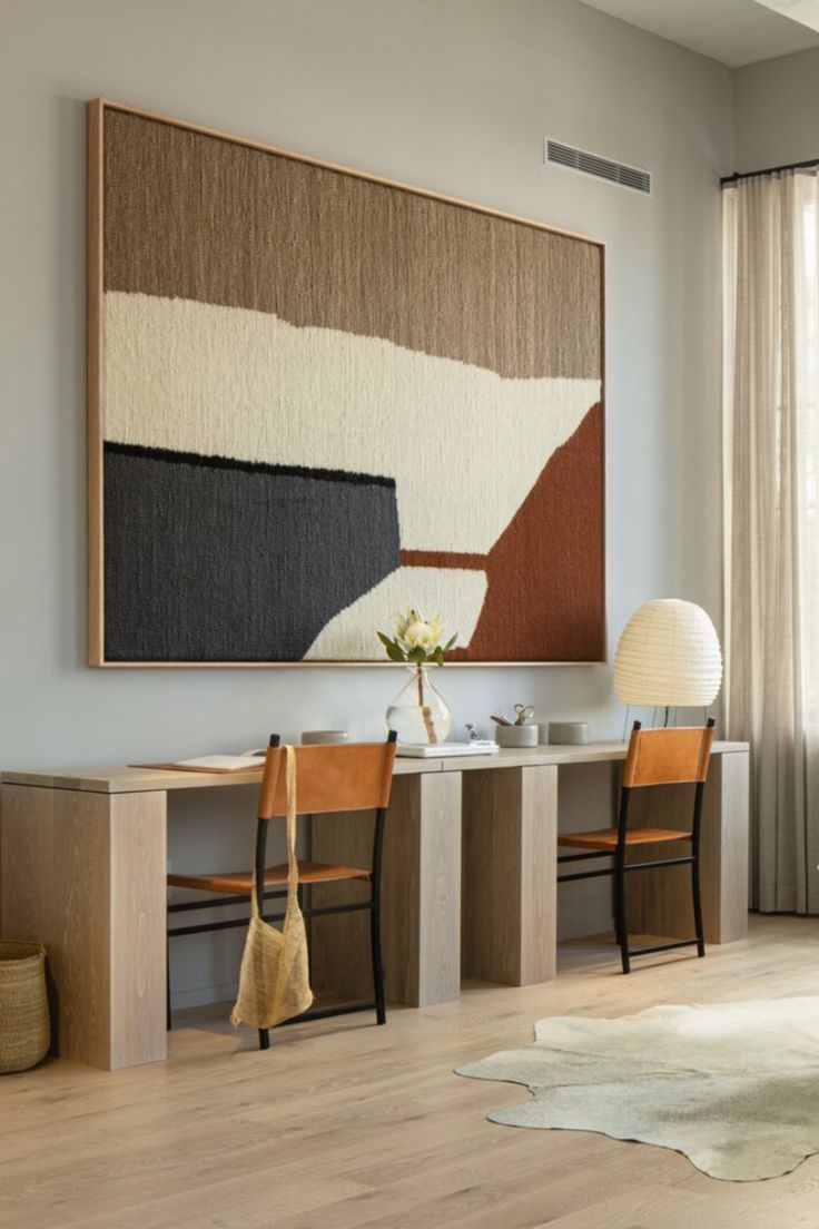 a painting hanging on the wall above a dining room table