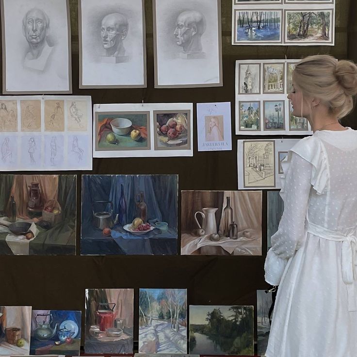 a woman standing next to a wall covered in pictures