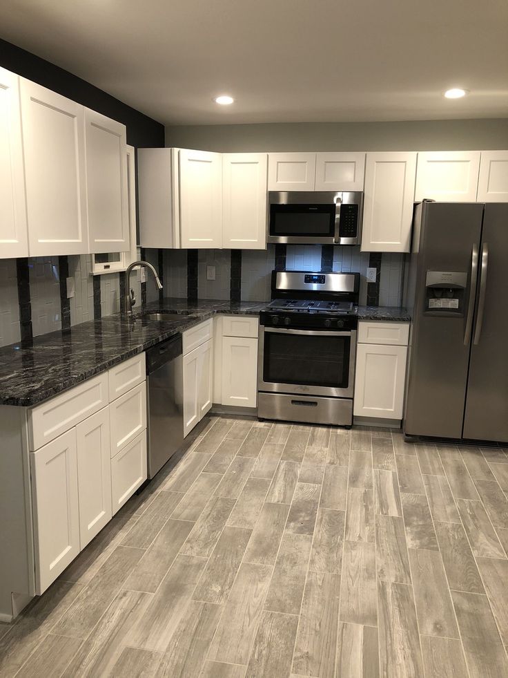 a kitchen with stainless steel appliances and white cabinets