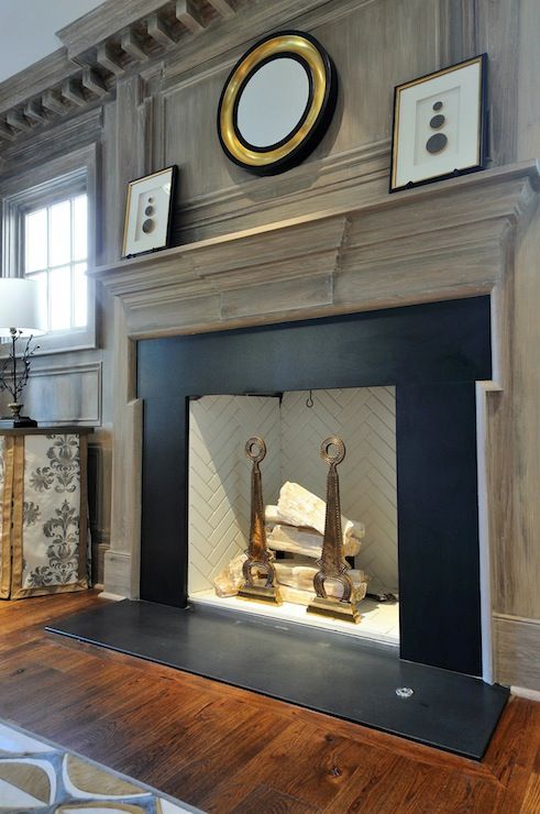 a living room filled with furniture and a fire place in the middle of a wooden floor