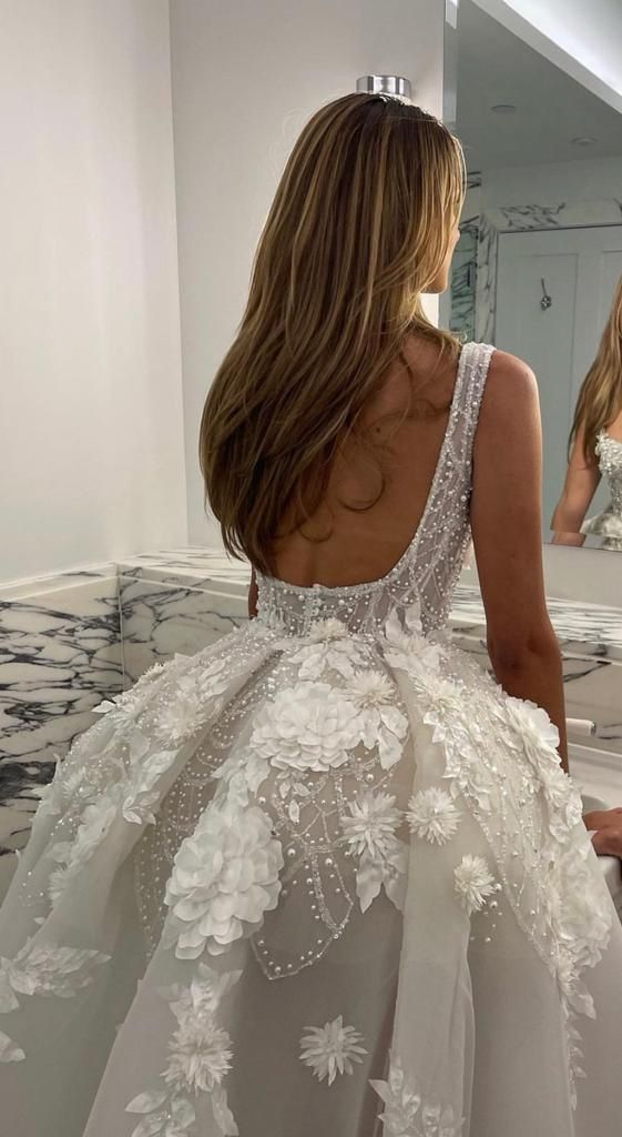 the back of a woman's dress in front of a mirror with flowers on it