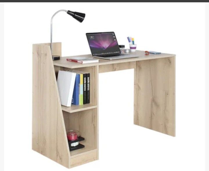 a computer desk with a laptop on it and bookshelf in front of it