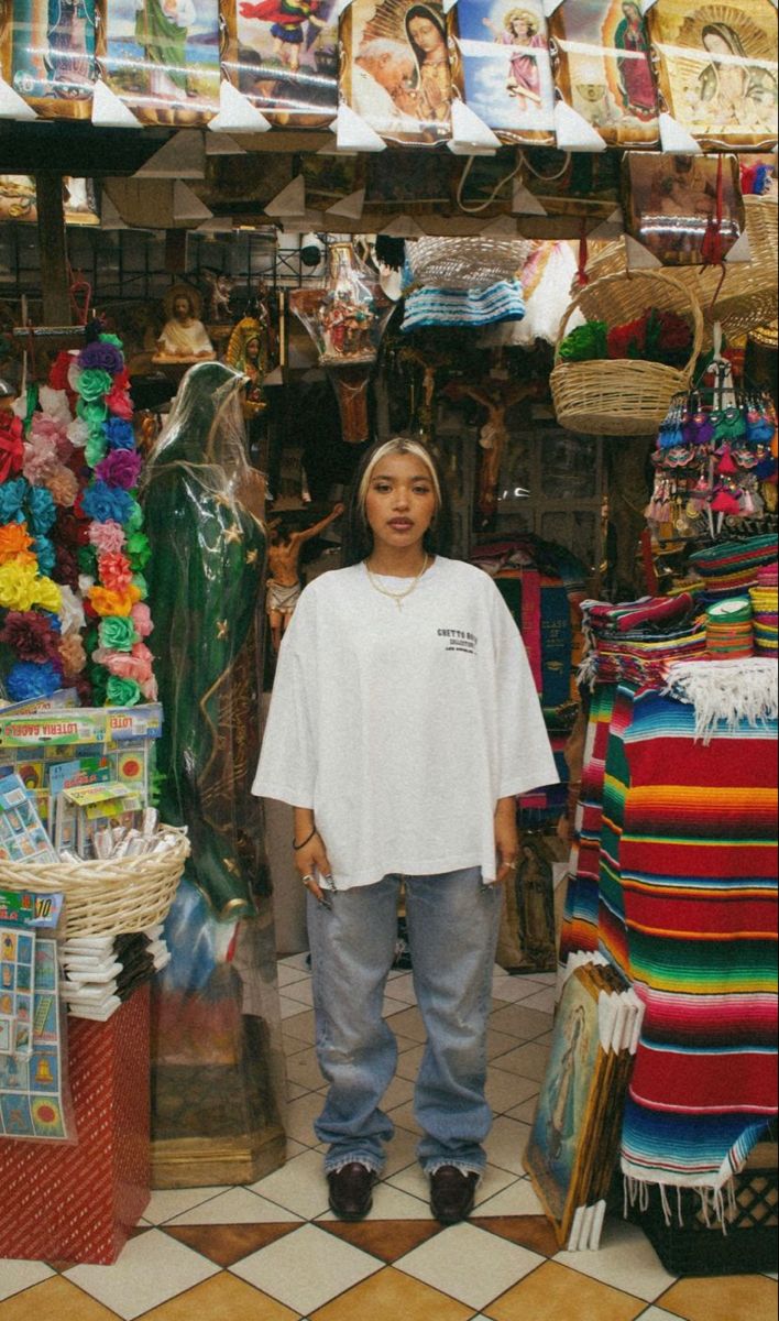 a young man standing in front of a store filled with colorful items and souvenirs