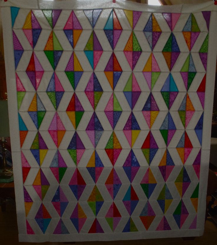 a colorful quilt hanging on the wall