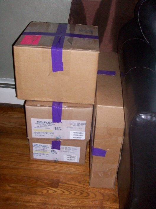 two boxes stacked on top of each other with purple tape wrapped around the bottom one