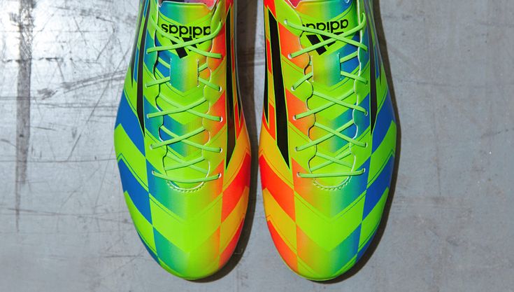 a pair of soccer cleats painted with rainbow colors