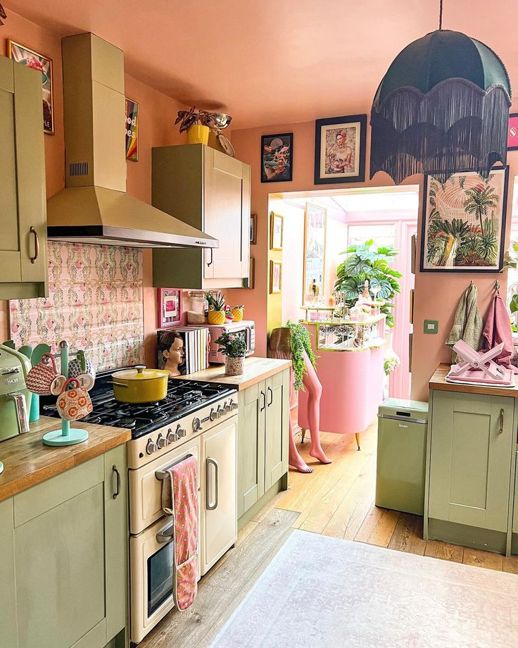 a kitchen with green cabinets and pink walls