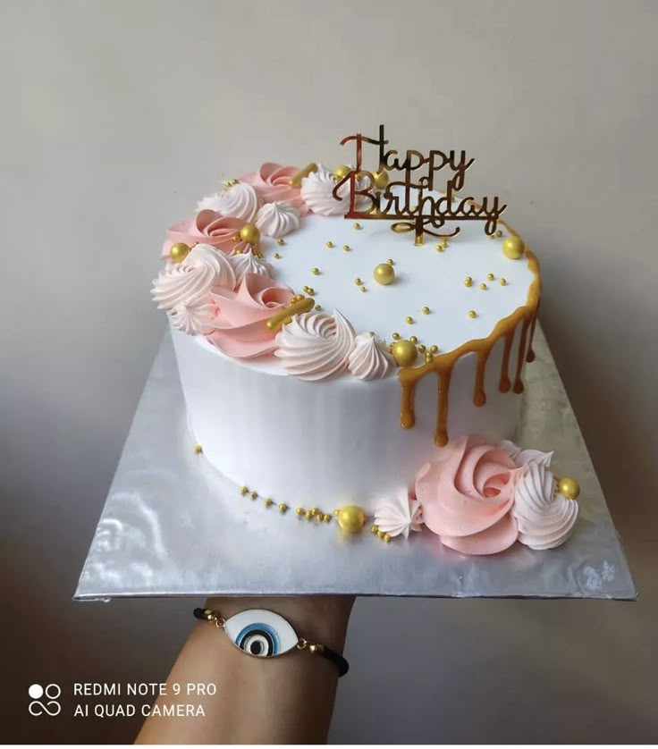 a birthday cake with pink and white frosting