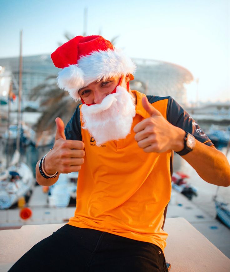 a man with a santa hat gives the thumbs up