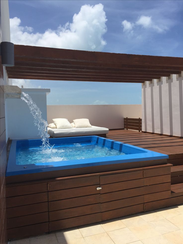 an outdoor hot tub on the roof of a building with water shooting out of it